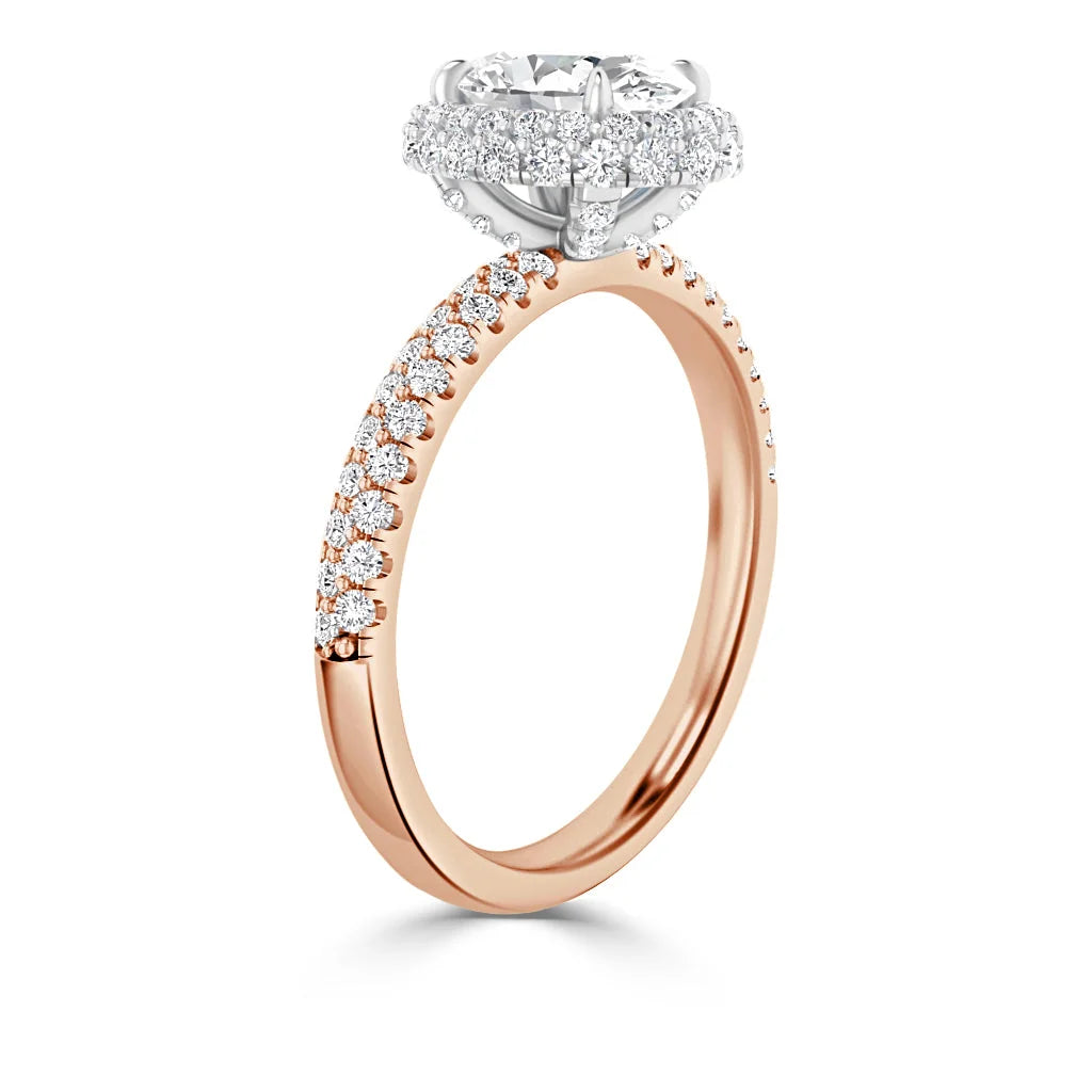 A rose gold ring with a round diamond halo setting and pavé diamonds along the band, shown on a white background.