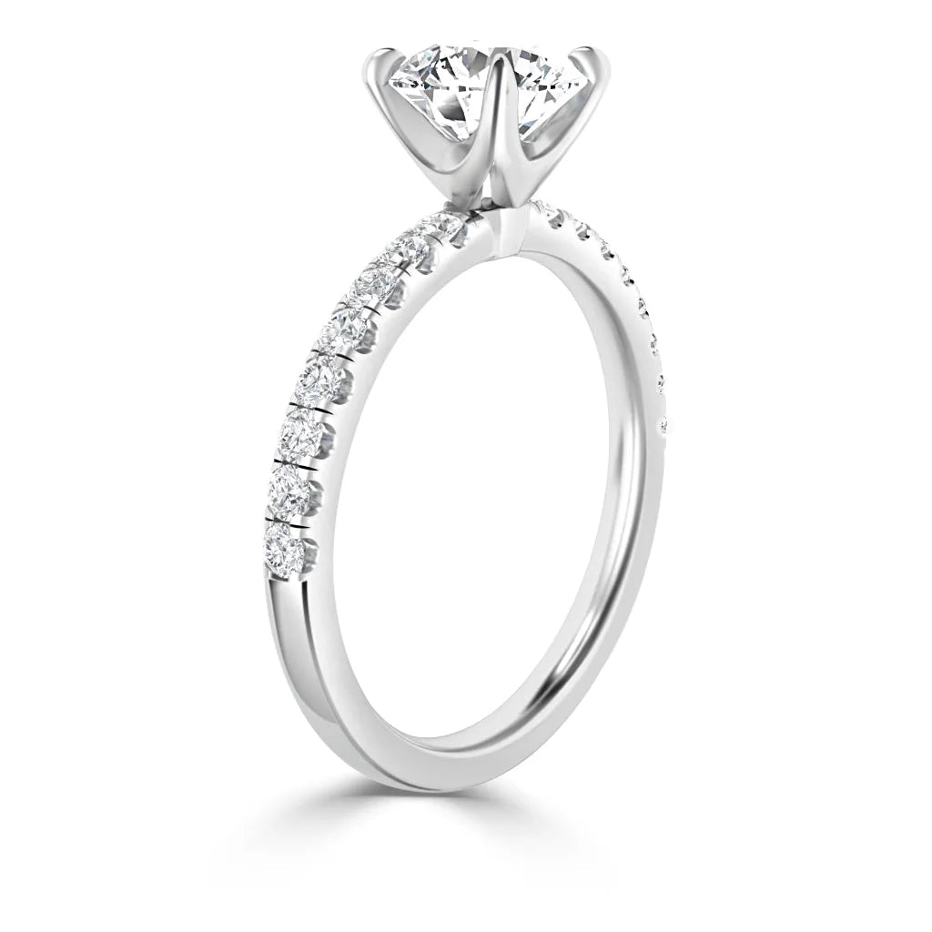 A white gold ring with a large round center diamond and smaller diamonds set along the band.