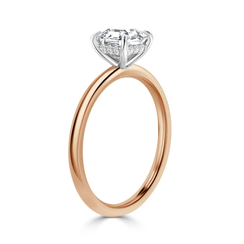 A rose gold ring with a round, prong-set diamond solitaire on a thin, polished band.