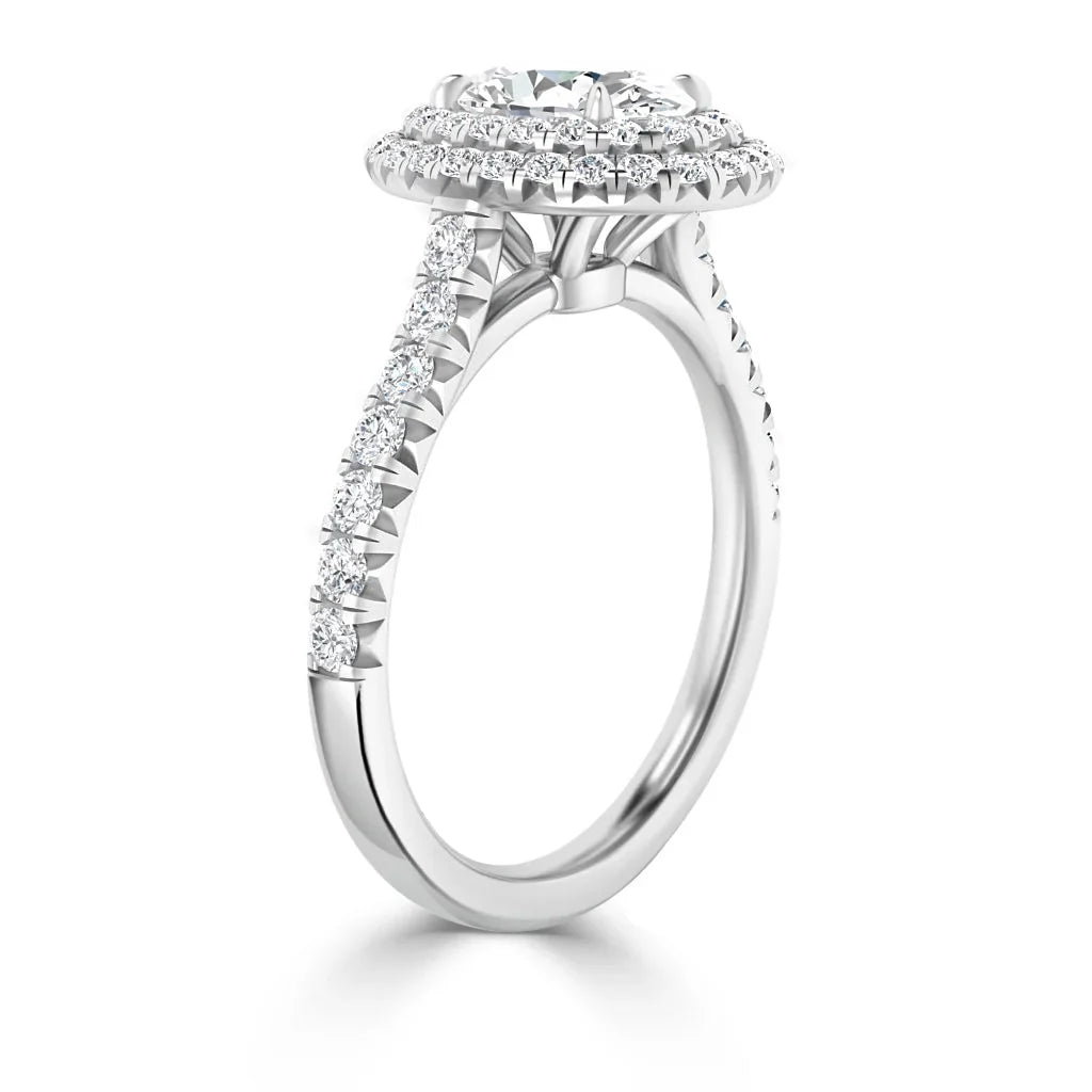 White gold engagement ring with a double halo and pavé diamonds along the band, side view.