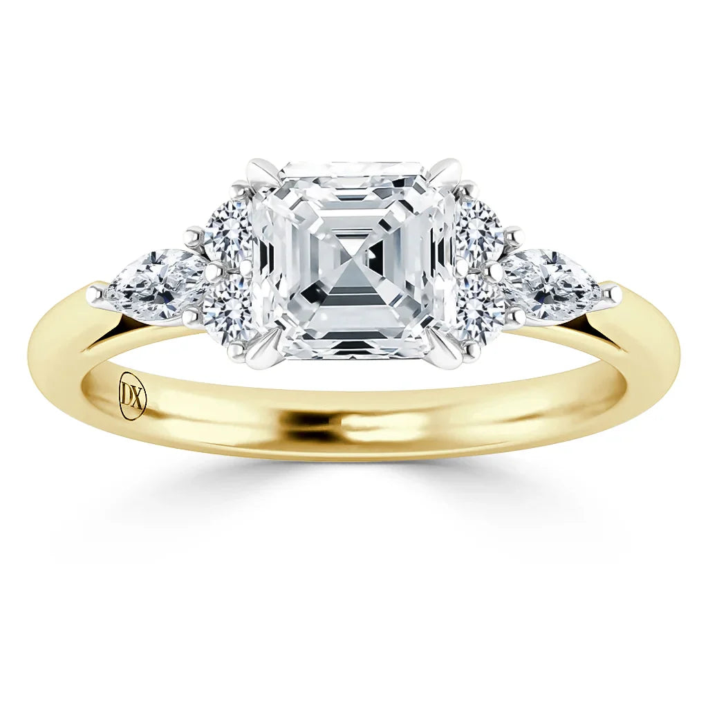 Gold band ring with a large square diamond center flanked by two round and two pear-shaped side diamonds.