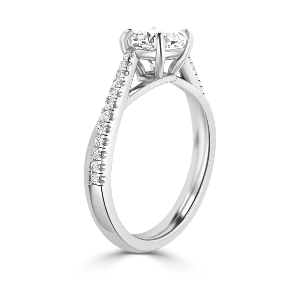 A white gold engagement ring with a round center diamond and pavé diamonds along the band, shown in profile.