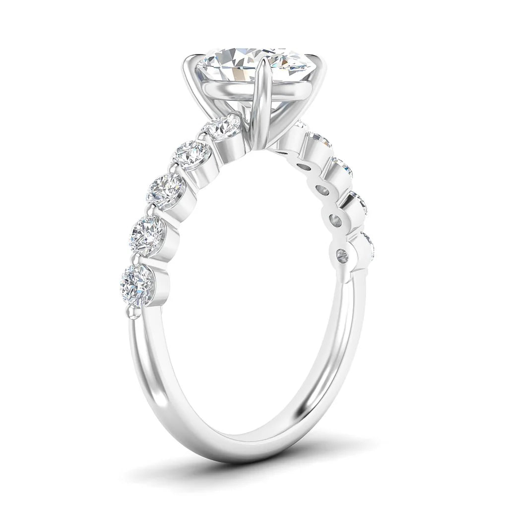 A silver ring with a large round diamond and smaller diamonds set along the band, shown from a side angle.