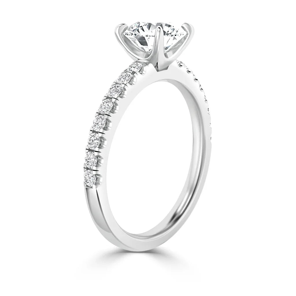 A white gold engagement ring with a round solitaire diamond and small diamonds along the band.