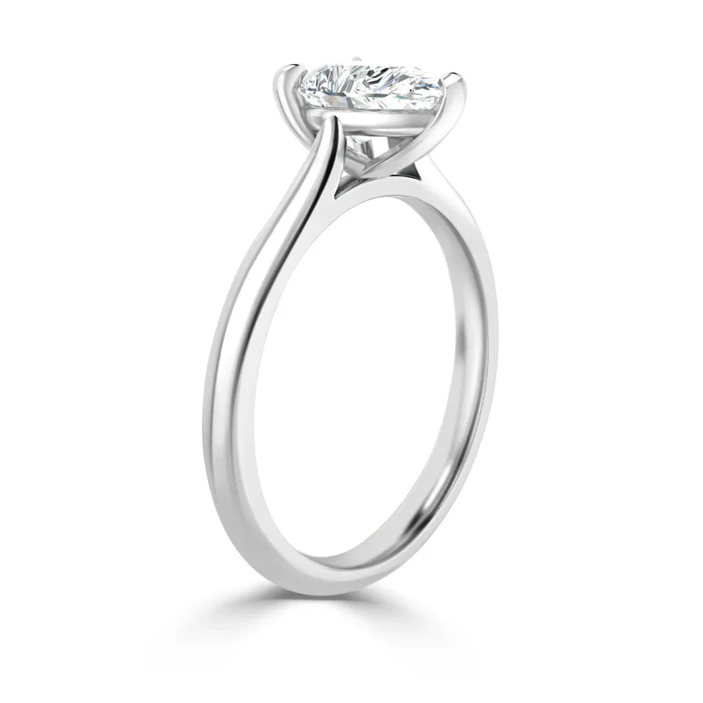 Side view of a silver solitaire ring with a round diamond set in a simple, elegant prong setting.