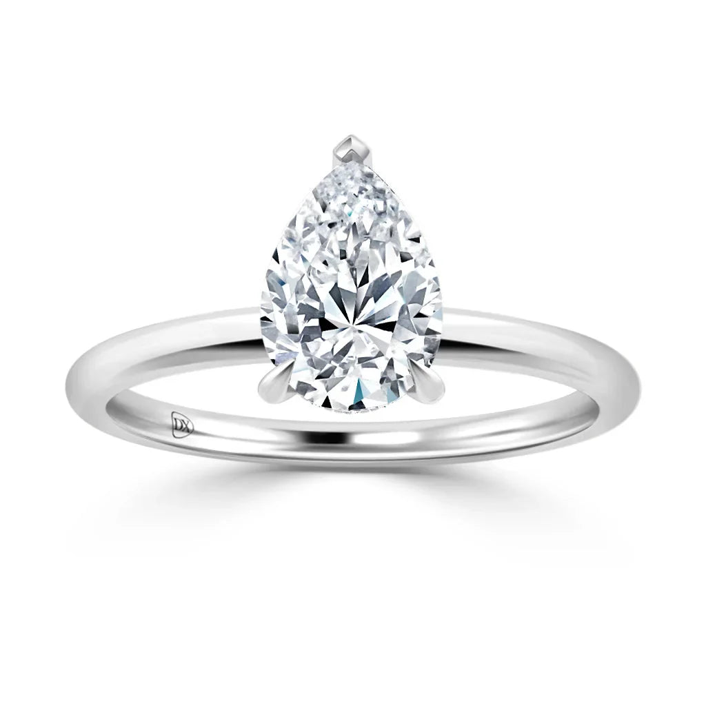 A solitaire ring with a pear-shaped diamond set on a simple, polished silver band.
