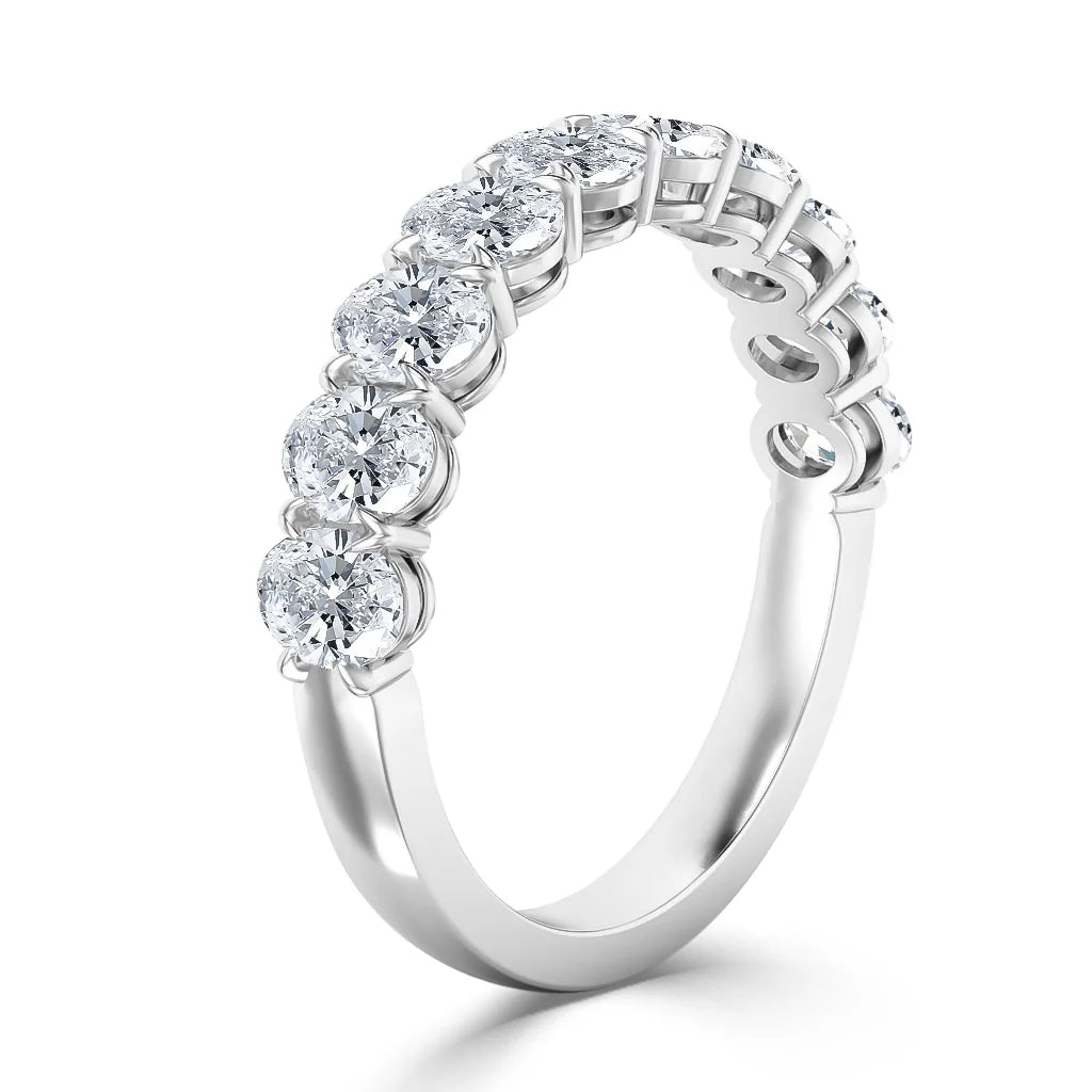 A white gold ring with seven round diamonds set in a row along the top of the band.