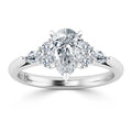 A pear-shaped diamond ring with side diamonds set in a polished silver band, viewed from the front.