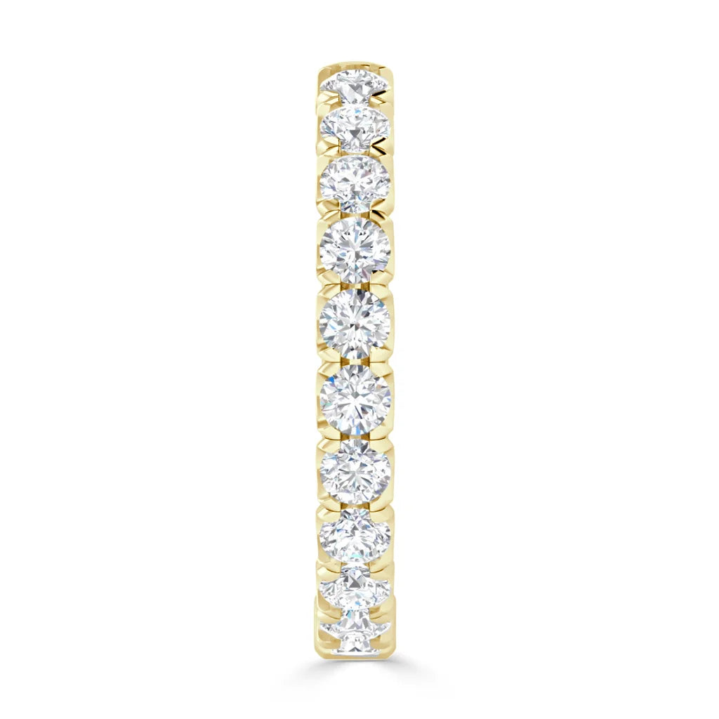 A gold ring with a row of round, sparkling white diamonds set along the band, shown from the front.