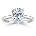 A pear-shaped diamond solitaire ring with a simple, polished white gold band on a white background.