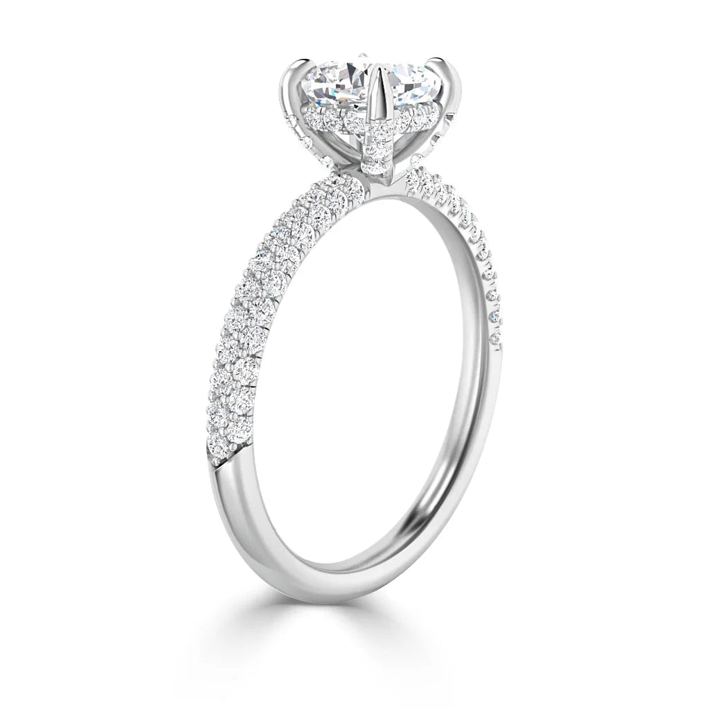 White gold ring with a large round diamond center stone and pavé diamonds along the band, viewed at an angle.