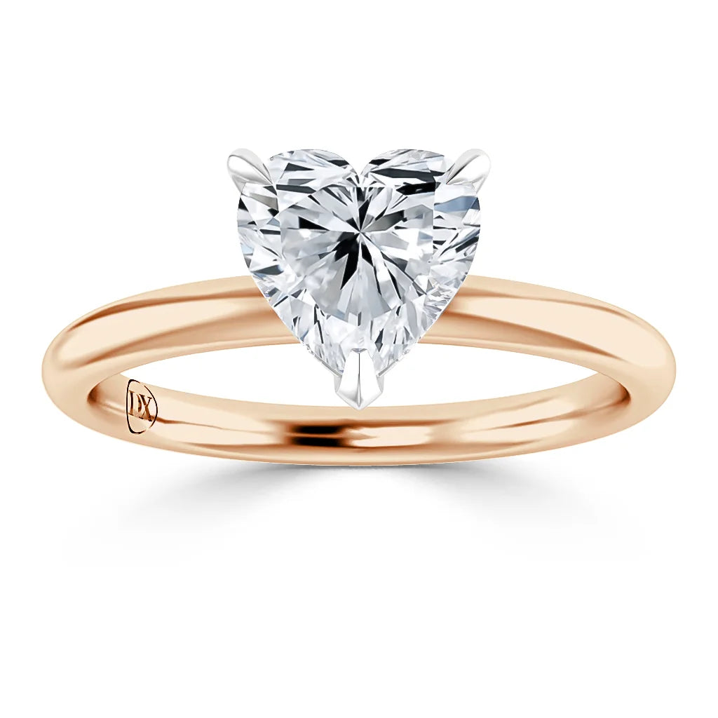 A gold ring with a heart-shaped diamond solitaire set in a minimalist prong setting, viewed from the front.