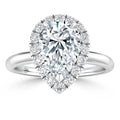 Pear-shaped diamond ring with a halo of smaller diamonds on a simple silver band, viewed from above.