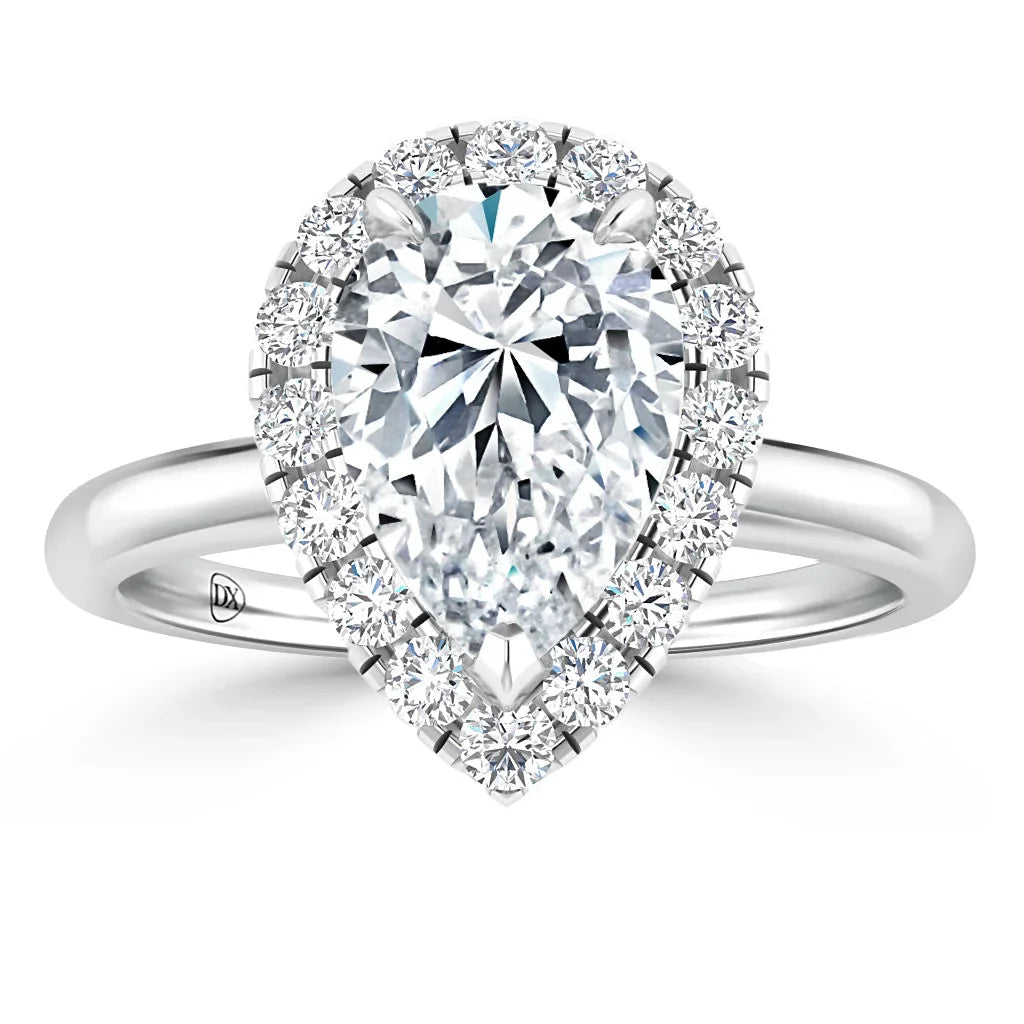 Pear-shaped diamond ring with a halo of smaller diamonds on a simple silver band, viewed from above.