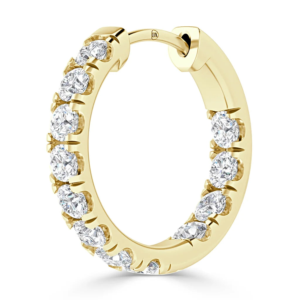 A gold hoop earring set with round white diamonds along the front, shown against a white background.