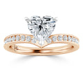 Rose gold ring with a heart-shaped diamond center and a band set with round diamonds.