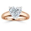 Heart-shaped diamond ring with a rose gold band and prong setting against a white background.