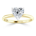 A gold ring with a heart-shaped diamond solitaire set in a simple, polished band against a white background.