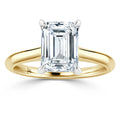 Emerald-cut diamond solitaire ring with a yellow gold band and four-prong white gold setting.