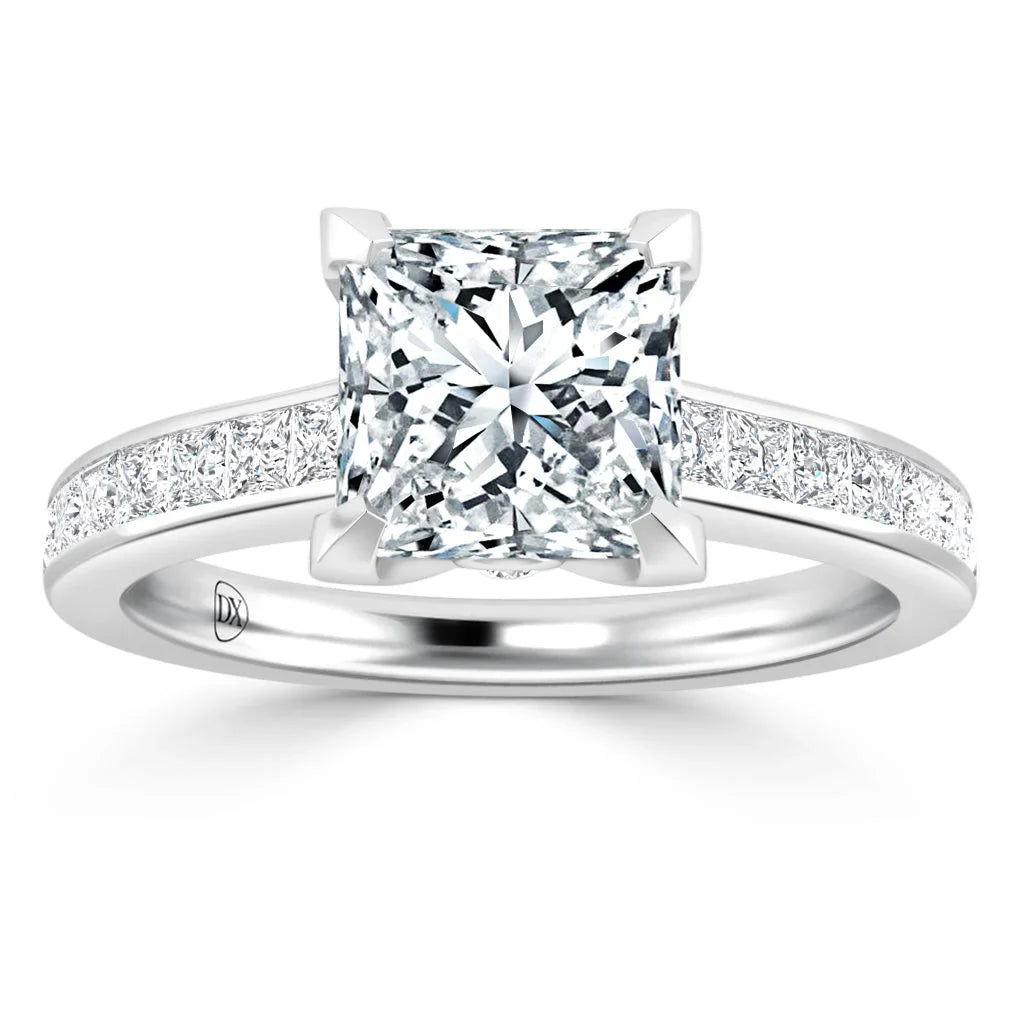 A platinum ring with a large princess-cut diamond center and smaller diamonds set along the band.