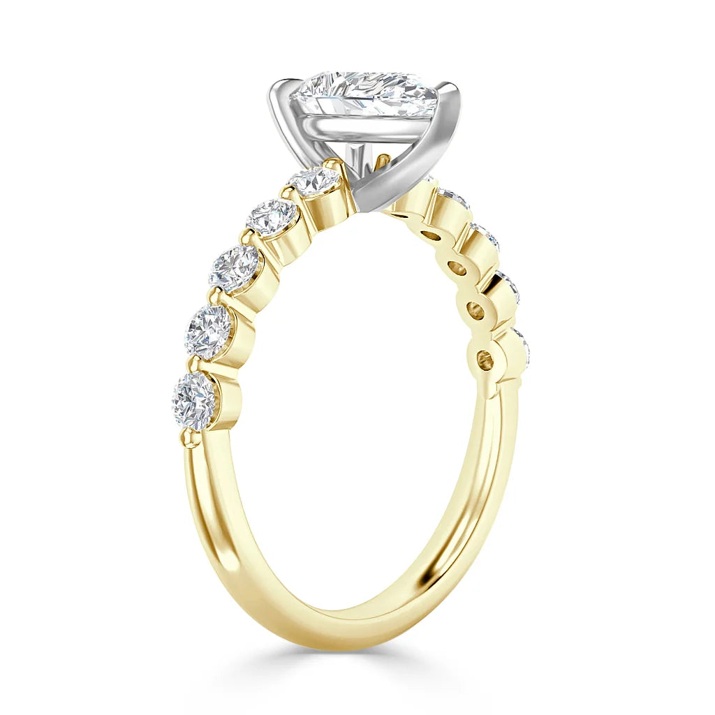 Gold ring with side diamonds and a marquise-cut center stone held in a white metal prong setting.