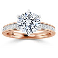 Rose gold ring with a large round diamond center and smaller diamonds set along the band.
