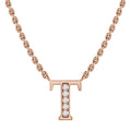 A rose gold necklace with a “T” pendant encrusted with small, sparkling diamonds on a fine chain.