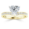 Gold ring with a heart-shaped diamond center and small diamonds along the band.