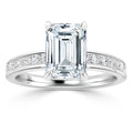Platinum ring with emerald-cut diamond center and channel-set round diamonds along the band.