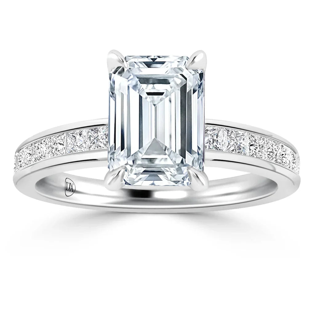 Platinum ring with emerald-cut diamond center and channel-set round diamonds along the band.