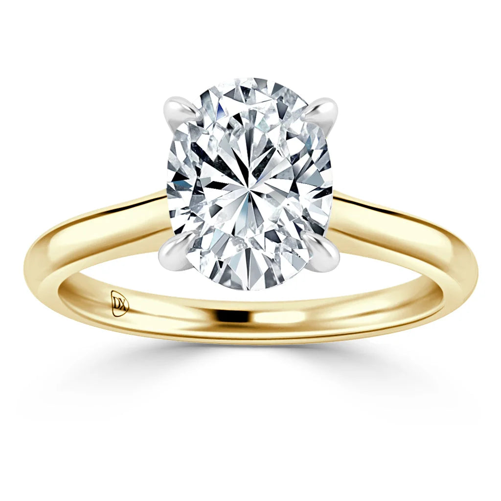 A gold ring with a large, oval-cut diamond solitaire held by four prongs on a plain band.