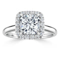 Cushion-cut diamond ring with a halo of smaller diamonds on a polished white gold band.