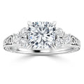 White gold ring with a large round center diamond, six side diamonds, and delicate filigree on the band.