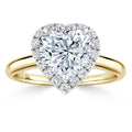 Heart-shaped diamond ring with a gold band and a halo of small round diamonds around the center stone.