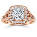 Rose gold ring with cushion-cut center diamond, double halo, and intricate diamond-accented band detailing.