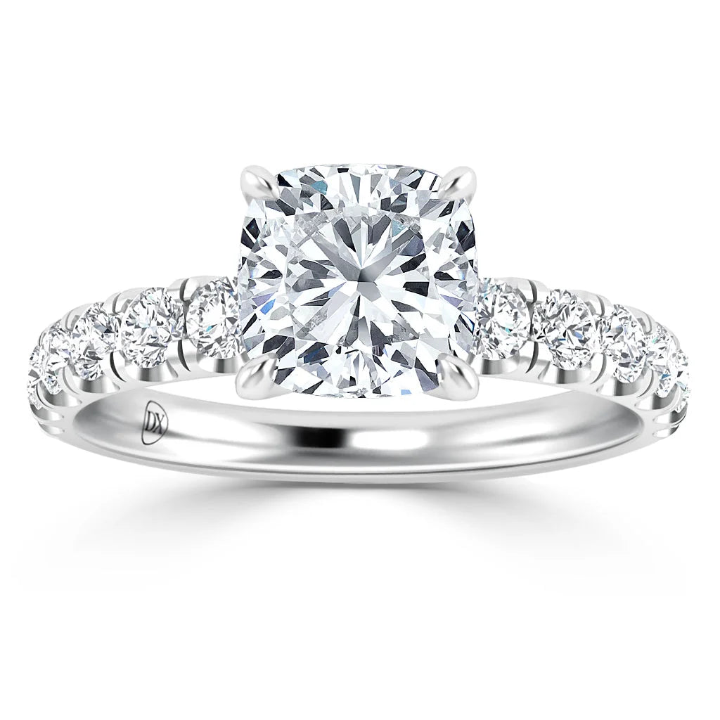 Cushion-cut diamond ring with side diamonds set on a polished white gold band, viewed from the front.