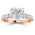Rose gold ring with a heart-shaped diamond center and round diamonds set along the band.