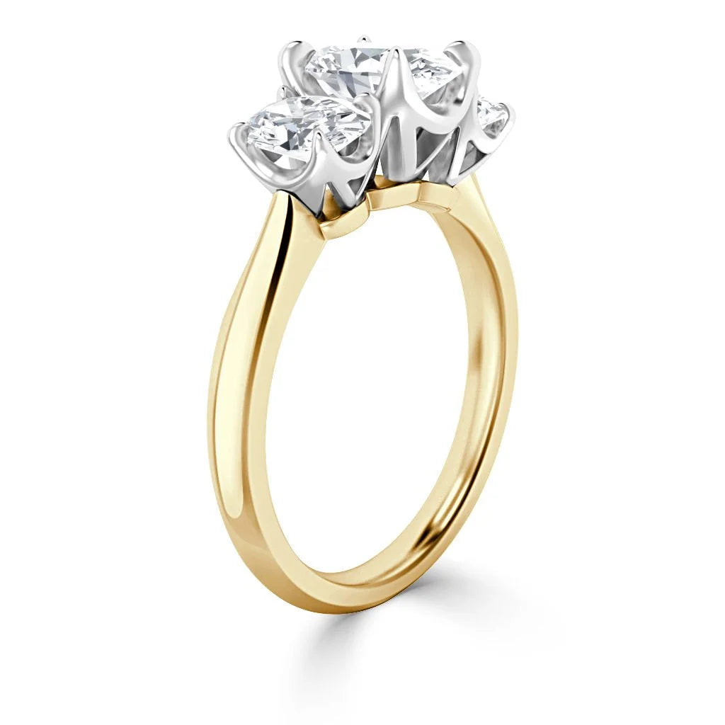 A gold ring with three round diamonds set in a silver prong setting on a plain gold band.