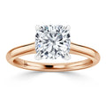 A cushion-cut diamond solitaire ring with a rose gold band and four prongs holding the diamond.