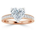 Rose gold ring with a heart-shaped diamond center and small diamonds set along the band.