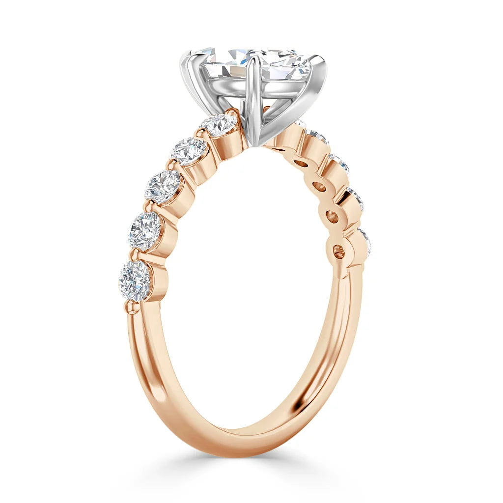 A rose gold ring with a large round diamond center and smaller diamonds set along the band.