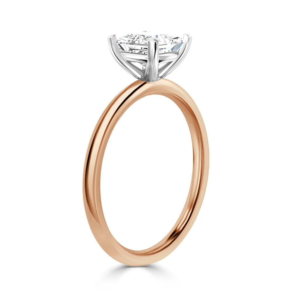 Rose gold engagement ring with a round diamond solitaire set in a white gold prong setting, shown in profile.