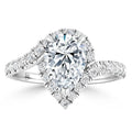 A pear-shaped diamond ring with a halo and band of smaller diamonds set in white metal.