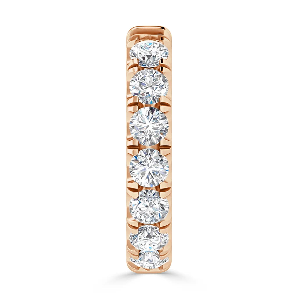 A rose gold ring set with seven round, sparkling diamonds in a vertical row, shown from the front.
