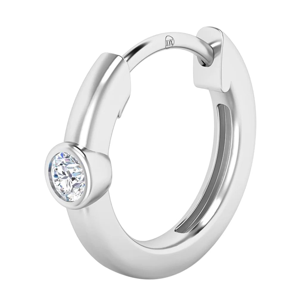 A silver hoop earring with a bezel-set round clear gemstone is shown against a white background.
