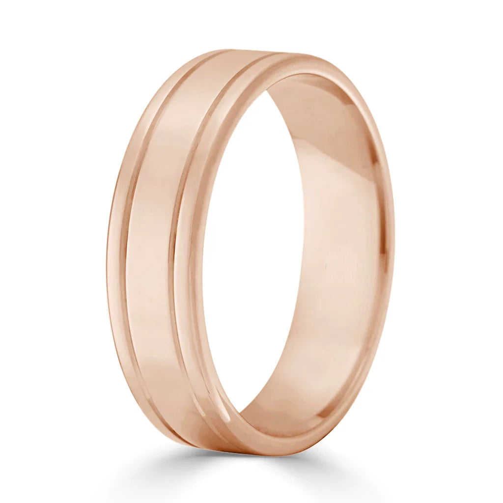 A rose gold wedding band with a single subtle groove around its center, set against a white background.
