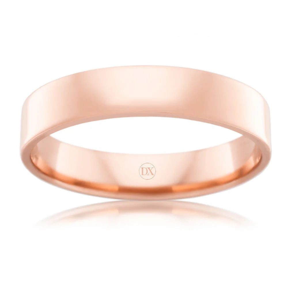 A simple, polished rose gold band ring with a flat surface and DX engraved inside.