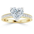 Gold ring with a heart-shaped diamond center and small diamonds set along the band.