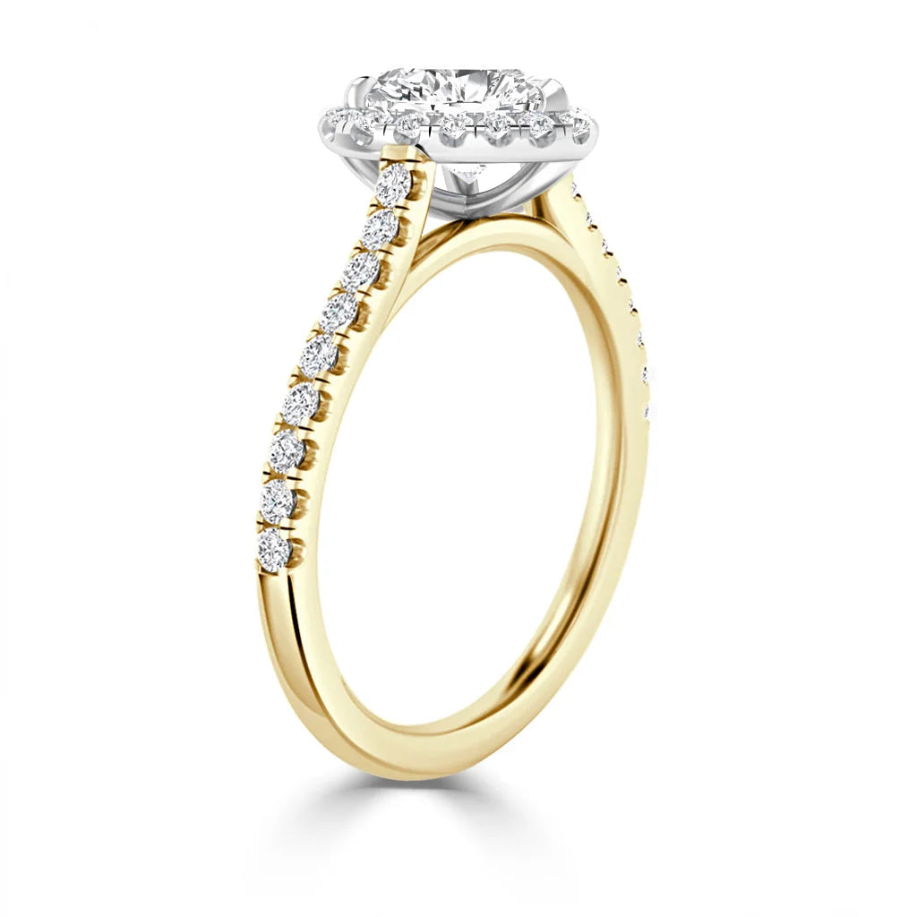 Gold engagement ring with a diamond halo setting and a band adorned with small round diamonds.