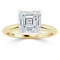 A gold ring with a large, square-cut diamond set in a four-prong setting on a plain band.